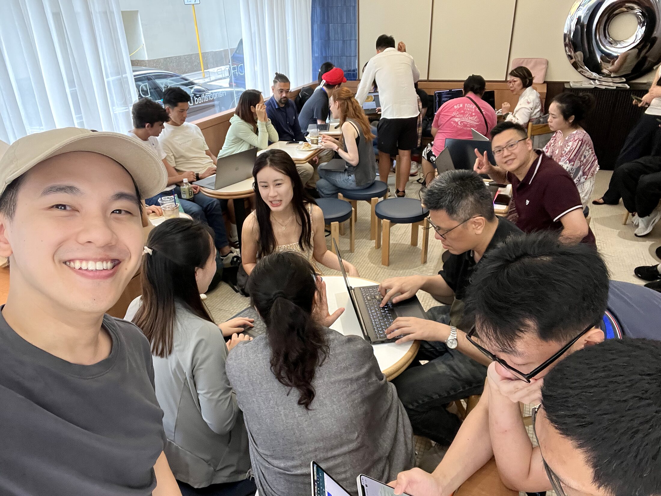 Eric Wong taking a wide selfie with the room during the DeepSeek OpenCode event