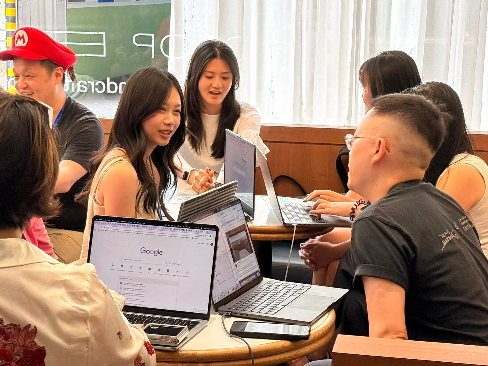 Small group working together around laptops at Drop By Dough